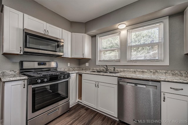 423 E Cherry St, Cushing, OK 74023 - kitchen featuring appliances with stainless steel finishes, a sink, white cabinets, and dark wood finished floors