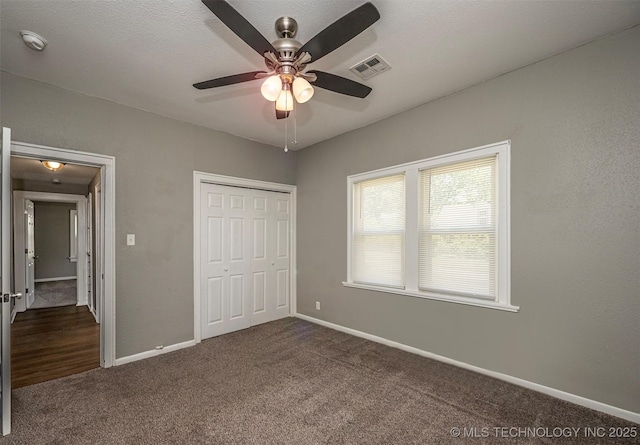 423 E Cherry St, Cushing, OK 74023 - unfurnished bedroom with dark carpet, baseboards, a closet, and a ceiling fan