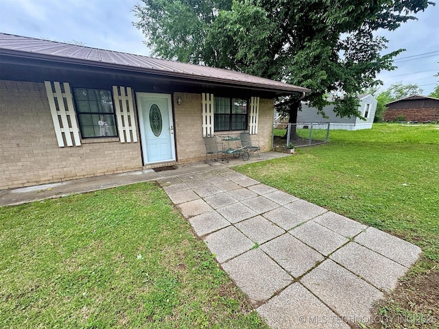 510 Beverly Ave, Vian, OK 74962 - view of front of house with a front yard, brick siding, metal roof, and a porch