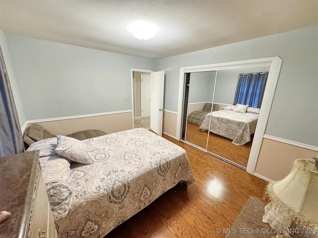 510 Beverly Ave, Vian, OK 74962 - bedroom with wood finished floors, a closet, a textured ceiling, and baseboards