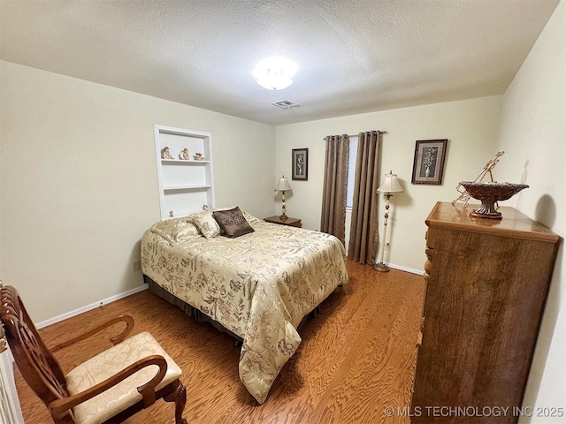 510 Beverly Ave, Vian, OK 74962 - bedroom with wood finished floors, baseboards, and a textured ceiling