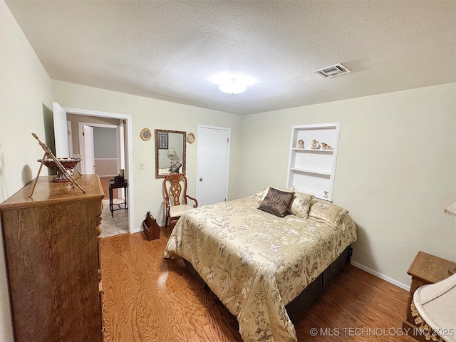 510 Beverly Ave, Vian, OK 74962 - bedroom with wood finished floors, baseboards, and a textured ceiling