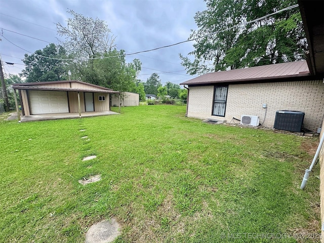 510 Beverly Ave, Vian, OK 74962 - view of grassy yard featuring a garage, cooling unit, an outbuilding, and driveway