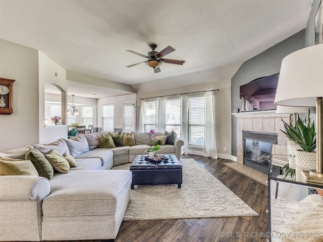 2008 N 8th St, Broken Arrow, OK 74012 - living area featuring a ceiling fan, a textured ceiling, a tiled fireplace, baseboards, and dark wood-style flooring