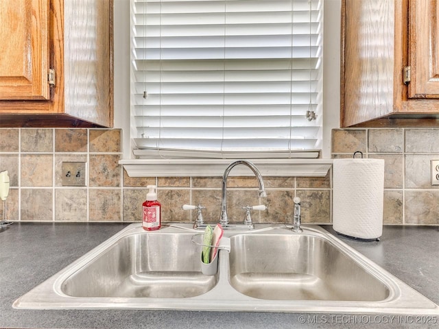 2008 N 8th St, Broken Arrow, OK 74012 - kitchen view of a sink, brown cabinetry, decorative backsplash, and dark countertops