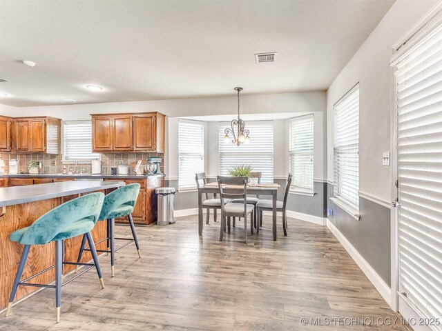 2008 N 8th St, Broken Arrow, OK 74012 - kitchen featuring light wood-style flooring, baseboards, tasteful backsplash, and brown cabinetry