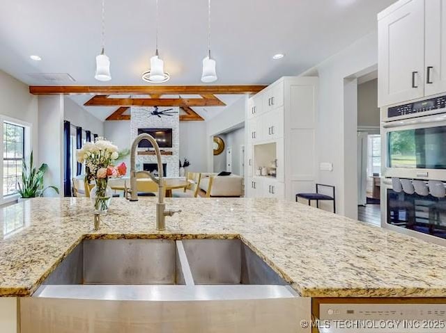 17716 S 39th W Ave, Mounds, OK 74047 - kitchen featuring a sink, beam ceiling, open floor plan, light stone counters, and decorative light fixtures