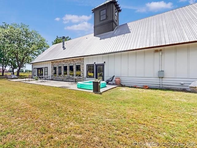 17716 S 39th W Ave, Mounds, OK 74047 - rear view of house with board and batten siding, a patio area, a lawn, and metal roof