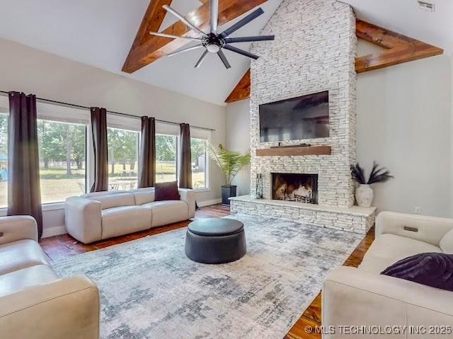 17716 S 39th W Ave, Mounds, OK 74047 - living room featuring high vaulted ceiling, a ceiling fan, a stone fireplace, plenty of natural light, and wood finished floors