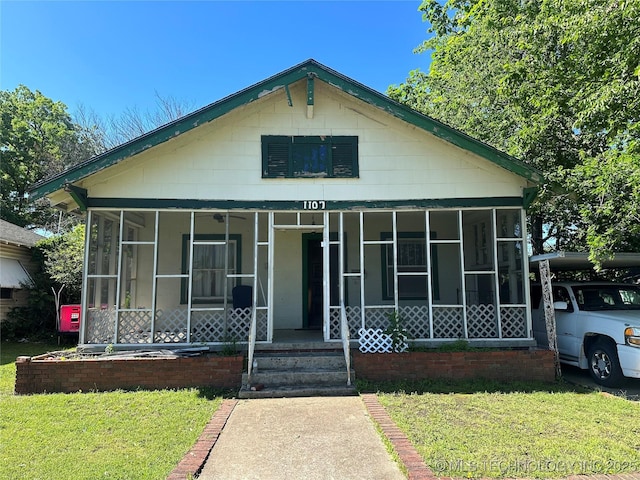 1107 W Broadway St, Henryetta, OK 74437 - view of front of property with a sunroom and a front yard