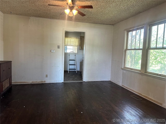 1107 W Broadway St, Henryetta, OK 74437 - unfurnished room with dark wood finished floors, a ceiling fan, and plenty of natural light