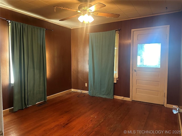 1107 W Broadway St, Henryetta, OK 74437 - foyer entrance featuring ornamental molding, a ceiling fan, wood finished floors, baseboards, and wood walls