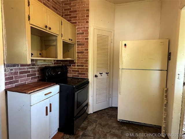 1107 W Broadway St, Henryetta, OK 74437 - kitchen with freestanding refrigerator, black / electric stove, dark countertops, dark stone finish flooring, and decorative backsplash