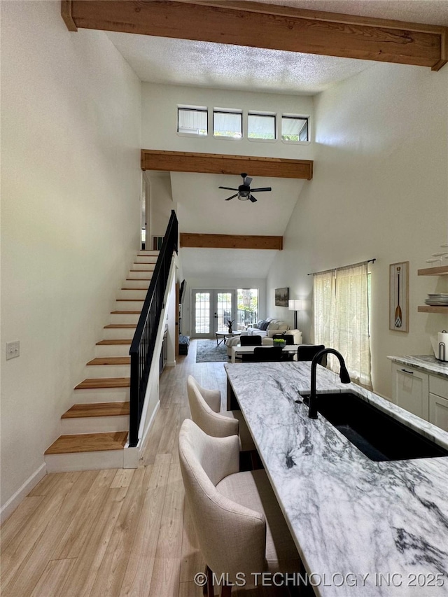 449734 E 356th Rd, Afton, OK 74331 - kitchen featuring a sink, beam ceiling, light wood finished floors, a ceiling fan, and light stone countertops