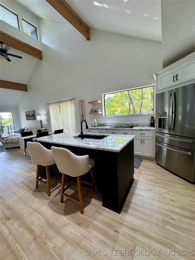 449734 E 356th Rd, Afton, OK 74331 - kitchen with stainless steel fridge with ice dispenser, high vaulted ceiling, a sink, an island with sink, and a kitchen bar