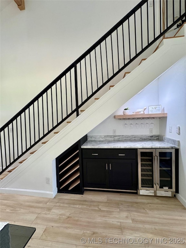 449734 E 356th Rd, Afton, OK 74331 - indoor dry bar with beverage cooler, light wood-style flooring, stairs, and baseboards