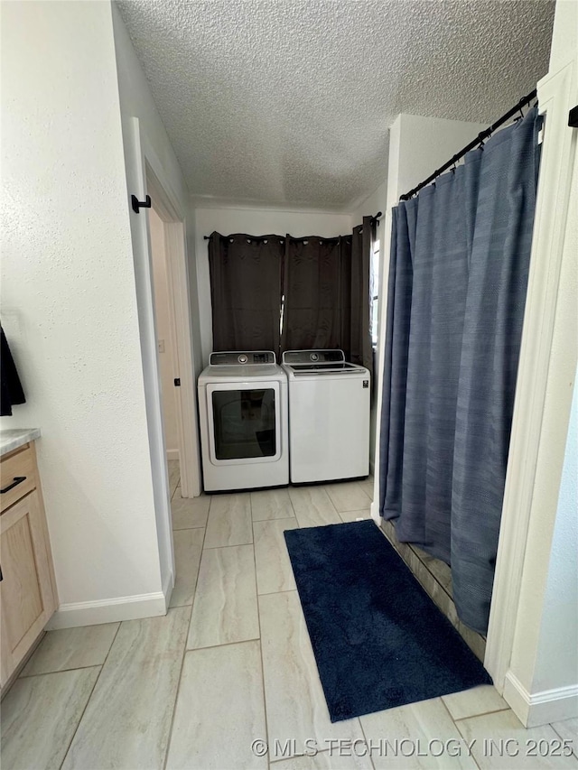 449734 E 356th Rd, Afton, OK 74331 - laundry room featuring washing machine and dryer, a textured ceiling, baseboards, and cabinet space