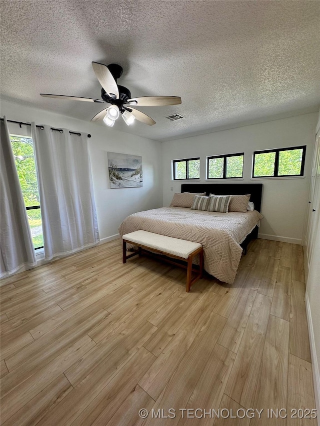 449734 E 356th Rd, Afton, OK 74331 - bedroom featuring a textured ceiling, baseboards, light wood-style flooring, and ceiling fan