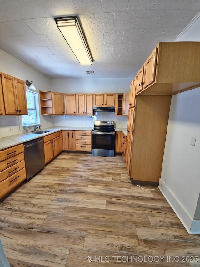 850 E Moses St, Cushing, OK 74023 - kitchen with appliances with stainless steel finishes, open shelves, range hood, light wood finished floors, and light countertops