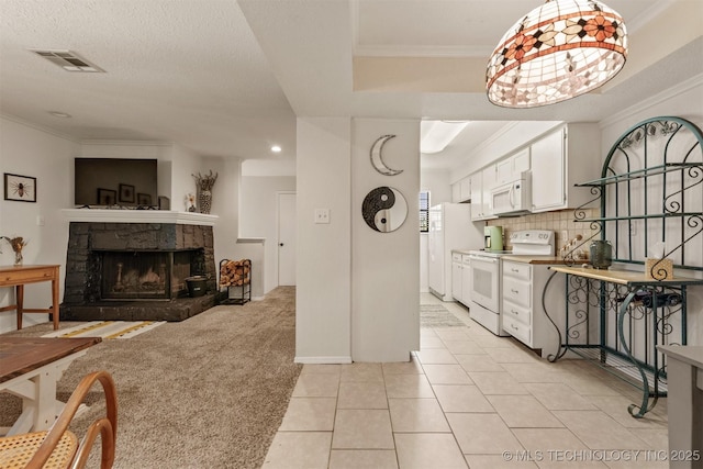 6353 S 80th E Ave Unit 1A, Tulsa, OK 74133 - kitchen featuring white appliances, white cabinets, ornamental molding, a stone fireplace, and light tile patterned flooring