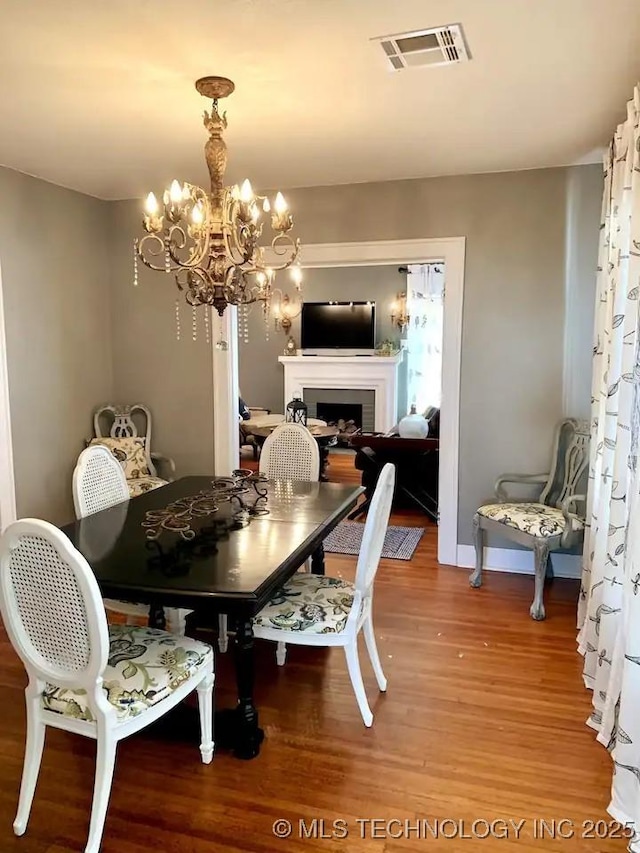 1124 W Elm, Durant, OK 74701 - dining area with light wood finished floors, a chandelier, a fireplace, and baseboards