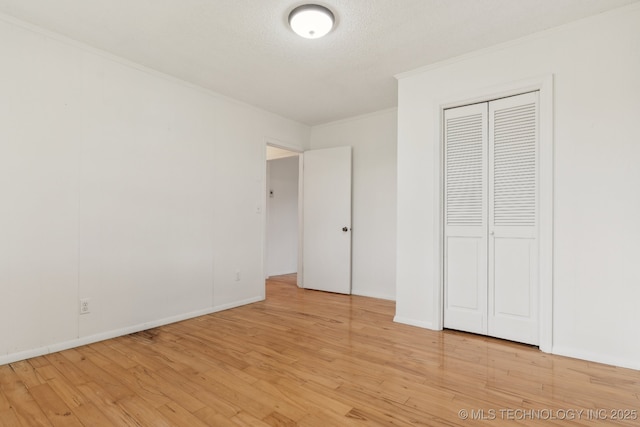 9590 S 4240th Rd, Chelsea, OK 74016 - unfurnished bedroom featuring crown molding, light wood finished floors, and a closet