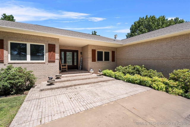 59144 E 290th Rd, Grove, OK 74344 - doorway to property featuring brick siding and a shingled roof