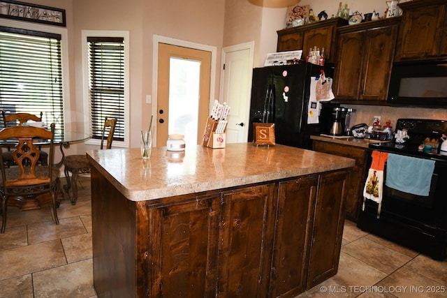 114 Stone, Roland, OK 74954 - kitchen featuring black appliances, a kitchen island, light stone countertops, and dark brown cabinetry