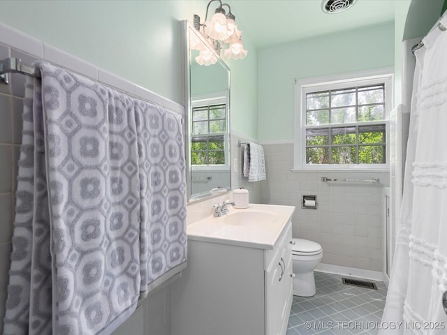 1724 Cherokee Pl, Bartlesville, OK 74003 - full bath with tile patterned flooring, tile walls, wainscoting, vanity, and toilet