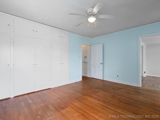 1724 Cherokee Pl, Bartlesville, OK 74003 - unfurnished bedroom featuring a closet, wood finished floors, baseboards, and a ceiling fan
