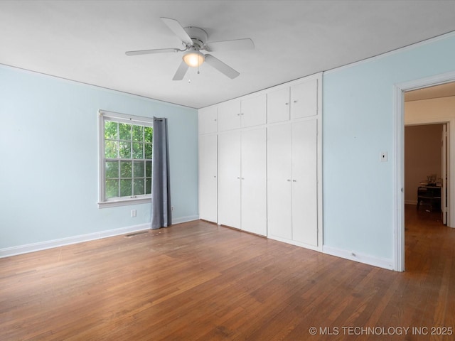1724 Cherokee Pl, Bartlesville, OK 74003 - unfurnished bedroom featuring wood finished floors, baseboards, a closet, and ceiling fan