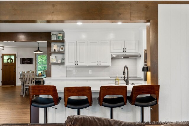 11837 S 84th Ave E, Bixby, OK 74008 - kitchen featuring tasteful backsplash, wood finished floors, white cabinets, light countertops, and a breakfast bar area
