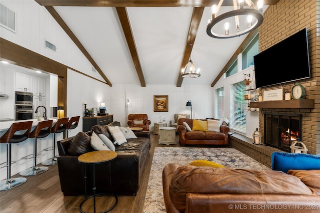 11837 S 84th Ave E, Bixby, OK 74008 - living room featuring a chandelier, dark wood-type flooring, a brick fireplace, beamed ceiling, and high vaulted ceiling