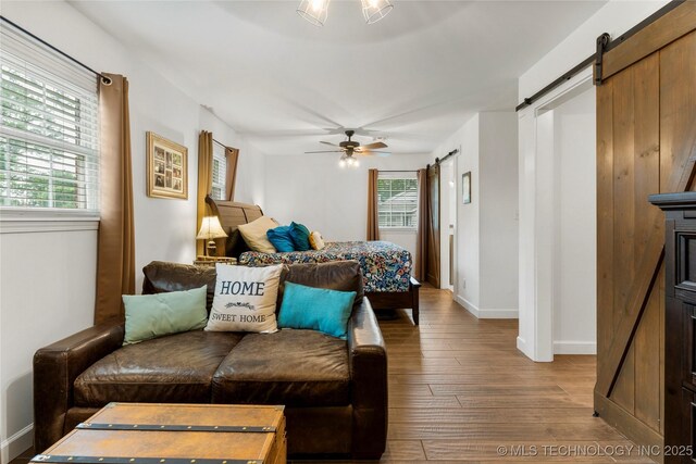 11837 S 84th Ave E, Bixby, OK 74008 - bedroom featuring a barn door, hardwood / wood-style floors, baseboards, and a ceiling fan