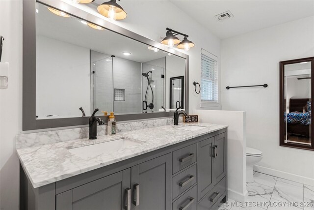 11837 S 84th Ave E, Bixby, OK 74008 - ensuite bathroom featuring marble look tile flooring, double vanity, a shower stall, baseboards, and toilet