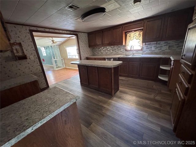 31206 E 683rd St, Wagoner, OK 74467 - kitchen with a sink, wallpapered walls, light countertops, a center island, and dark wood-style flooring