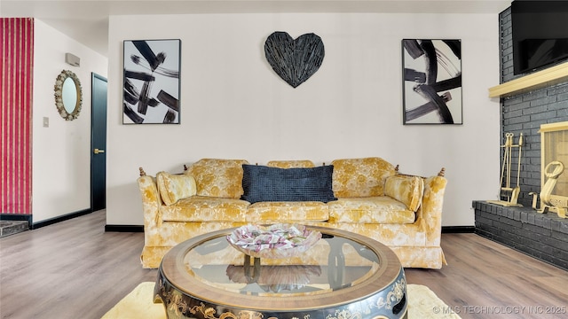 2014 12th Ave NW, Ardmore, OK 73401 - living area featuring wood finished floors, baseboards, and a brick fireplace