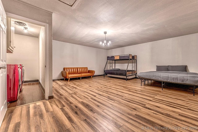 1114 Osage, Ardmore, OK 73401 - bedroom featuring wood finished floors, a chandelier, a textured ceiling, and baseboards