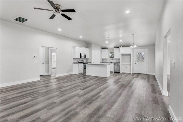 345 Kats, Durant, OK 74701 - unfurnished living room with wood finished floors, a ceiling fan, baseboards, recessed lighting, and lofted ceiling