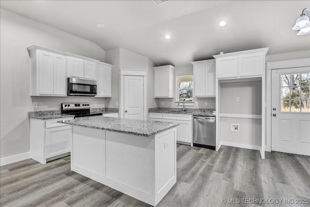 345 Kats, Durant, OK 74701 - kitchen featuring stainless steel appliances, healthy amount of natural light, lofted ceiling, white cabinets, and light wood-style floors