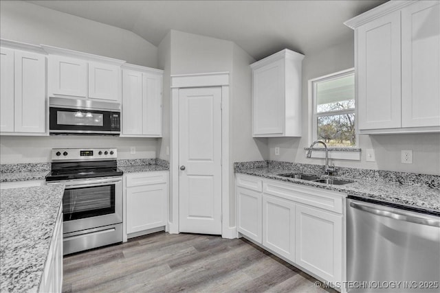 345 Kats, Durant, OK 74701 - kitchen featuring stainless steel appliances, a sink, light wood-type flooring, white cabinets, and lofted ceiling