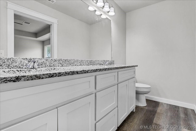 345 Kats, Durant, OK 74701 - full bathroom featuring wood finished floors, baseboards, toilet, and double vanity