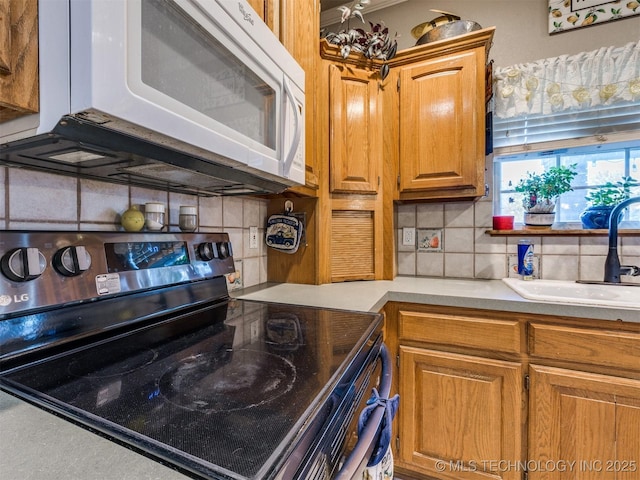 1821 N 11th St, Broken Arrow, OK 74012 - kitchen featuring electric range oven, white microwave, backsplash, light countertops, and a sink