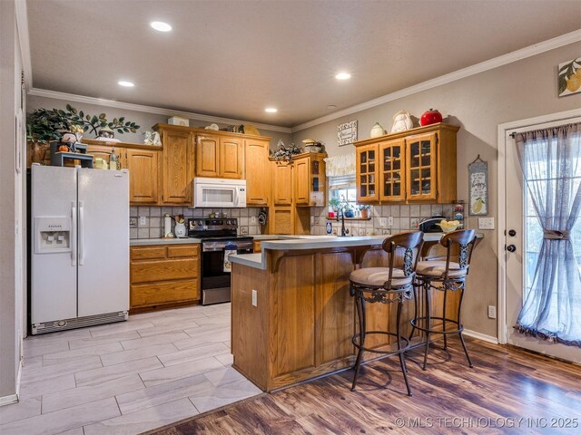 1821 N 11th St, Broken Arrow, OK 74012 - kitchen with white appliances, glass insert cabinets, a peninsula, decorative backsplash, and crown molding