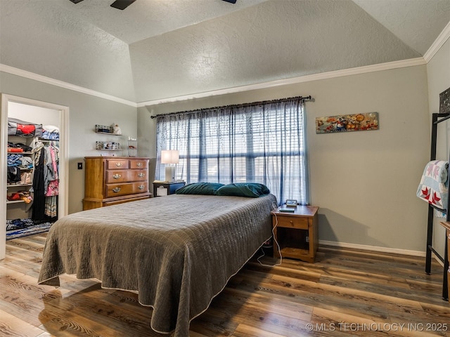 1821 N 11th St, Broken Arrow, OK 74012 - bedroom with vaulted ceiling, a textured ceiling, wood finished floors, a walk in closet, and crown molding