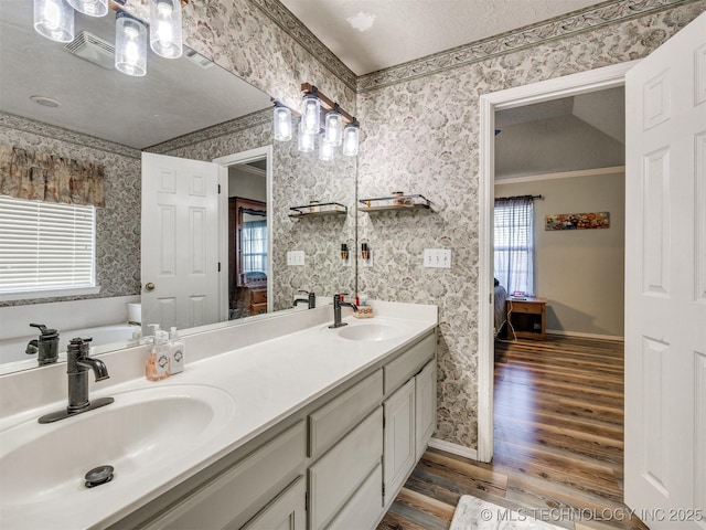 1821 N 11th St, Broken Arrow, OK 74012 - ensuite bathroom featuring wallpapered walls, double vanity, wood finished floors, baseboards, and a garden tub