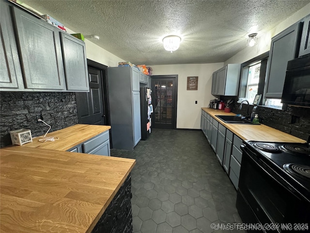 441 SE Carter St, Ardmore, OK 73401 - kitchen with wooden counters, black electric range, a sink, gray cabinets, and a textured ceiling
