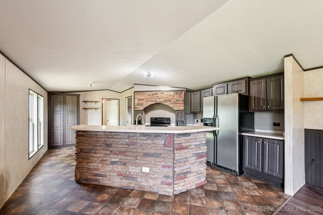 10180 S 241st W Ave, Sapulpa, OK 74066 - kitchen featuring stainless steel fridge, black / electric stove, light countertops, vaulted ceiling, and a kitchen island with sink
