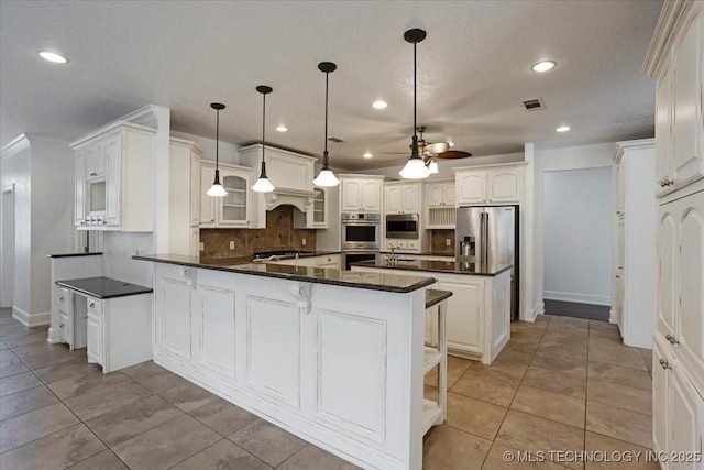 2259 E Rodeo Rd, Durant, OK 74701 - kitchen with stainless steel appliances, a peninsula, ceiling fan, dark countertops, and recessed lighting
