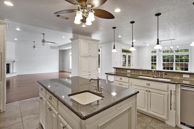 2259 E Rodeo Rd, Durant, OK 74701 - kitchen featuring a ceiling fan, a sink, dishwasher, a center island with sink, and a textured ceiling